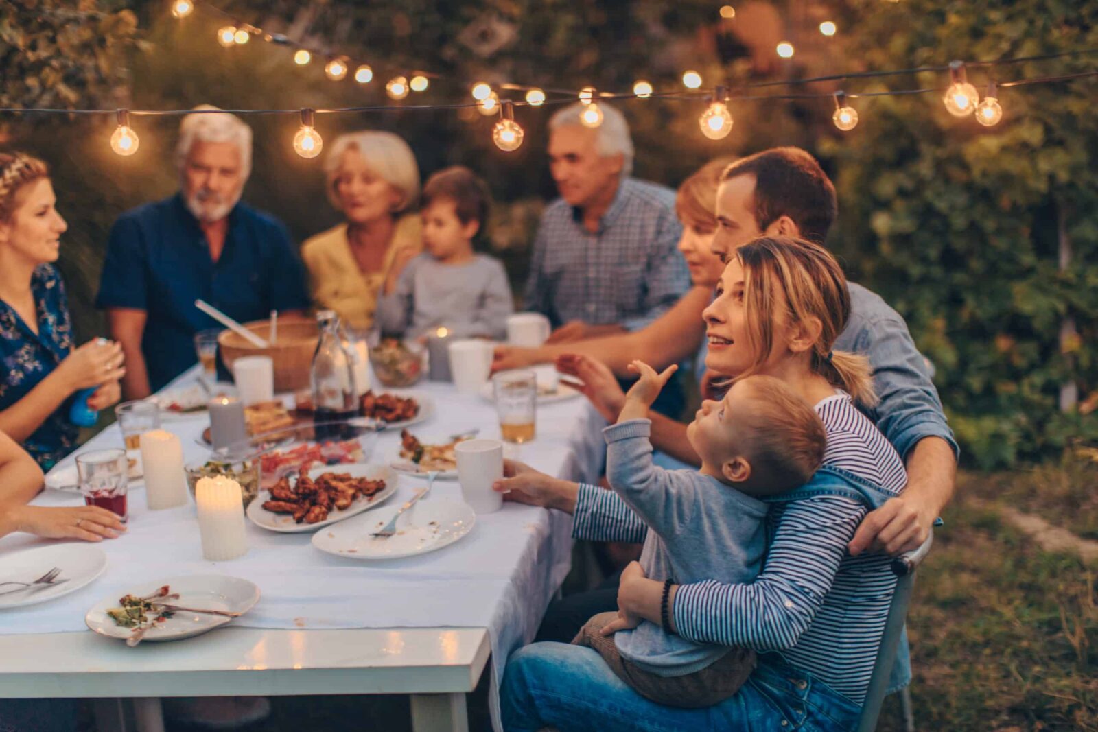 Photo d’une grande famille pendant le dîner de Thanksgiving, célébrant les vacances ensemble dans l’arrière-cour